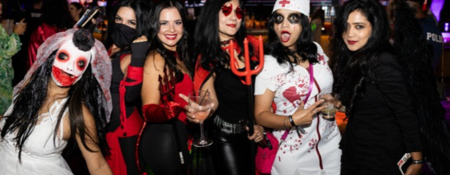 Group of female party goers dressed in costume for Haunted Hotel Halloween Party.