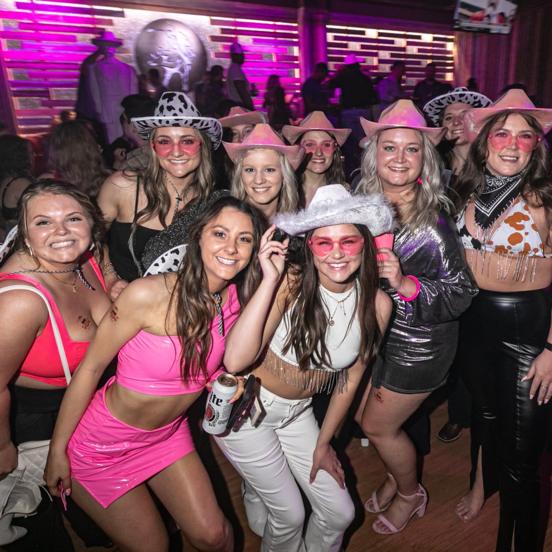 Group of women wearing cowboy hats celebrating a bachelorette party at Nashville Live!