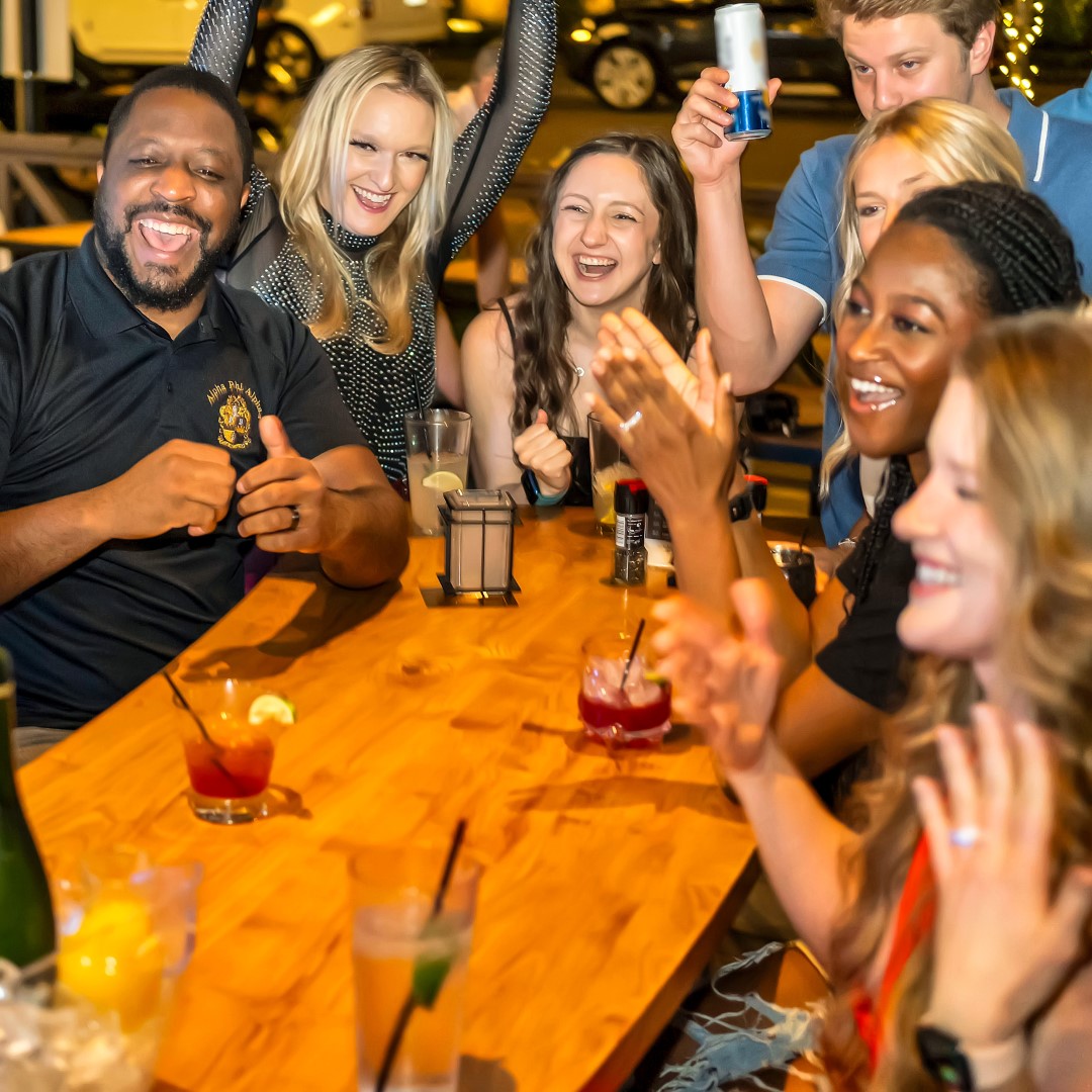 Group seated at table and enjoying cocktails.