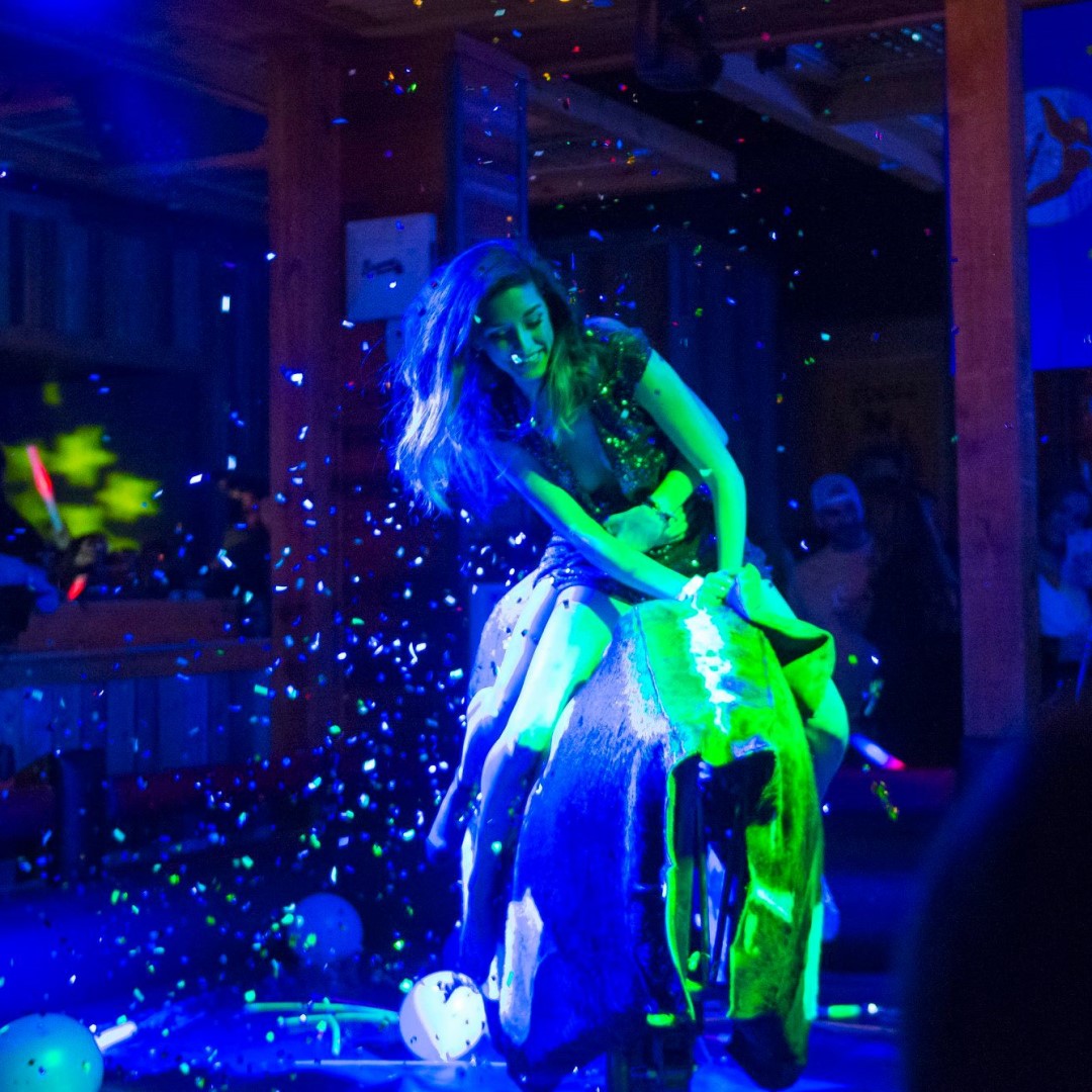 Woman riding mechanical bull at PBR Nashville for a birthday party.