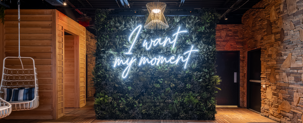 AVA Rooftop Bar green wall with 'I Want My Moment' sign